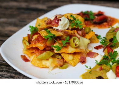 Super Nachos With Melted Cheese, Bacon, Sour Cream, Jalapeno Chilli Peppers, Salsa, Guacamole, Tortilla Chips, And Fresh Coriander.