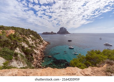 Super panoramic view Es Vedra rock on horizon and piercing blue summer sky full of ragged small white clouds, Ibiza, Balearic Islands, Spain