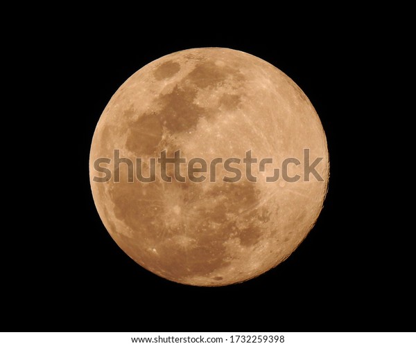 Super Pink Moon. Moon close up\
on night sky. Surface moon on black background. Moon\
Texture.