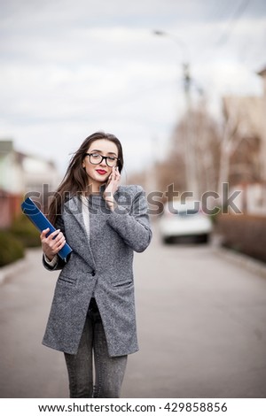 Super professional saleswoman, people concept - happy businesswoman with folder and mobile phone over property background