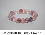 Super seven beautiful and lucky stone bracelet on white background. The stones contain Amethyst,  Clear Quartz, Smoky Quartz,  Cacoxenite,  Rutile,  Geothite  and Lepidocrocite.