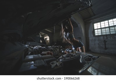 Super Sexy Chick Open Hood Of Muscle American Black Car In Old Dusty Garage