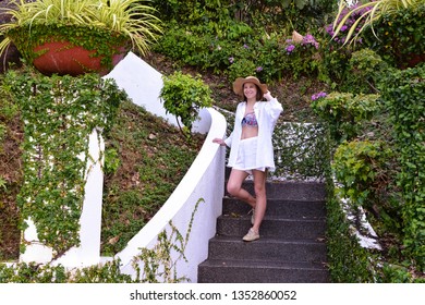 superb model sits on steps of stone staircase inside patio in Spa hotel,