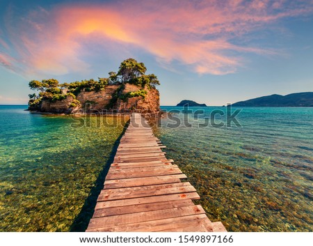 Superb summer sunrise on Port Sostis, Zakinthos island, Greece, Europe.  Wooden footbridge to Cameo Island. Beauty of nature concept background.