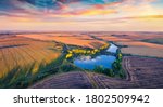 Superb summer sunrise on Ternopil outskirts with two lakes and asphalt road on the midle. Spectacular morning view of hte Ukrainian countryside. Vivid landscape of field of wheat.