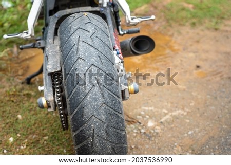 A superbike is parking on the dirt road, close-up and selective focus at the big tire. Ready for transportation and travel concept seen.