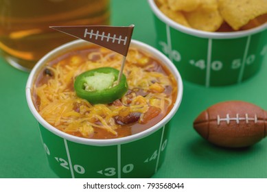 Superbowl Chili, Beer, And Party Snacks Closeup On Green Field Background