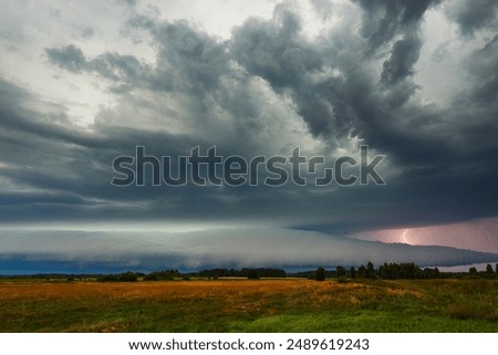 Supercell cloud with distant lightning illuminating the storm structure