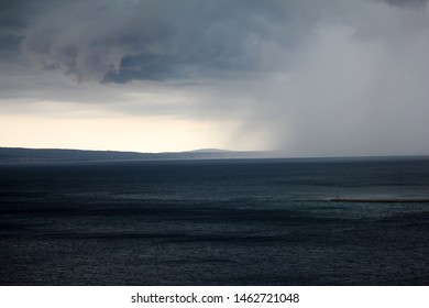 Supercell storm with dramatic dark cloud and rainstorm at the sea