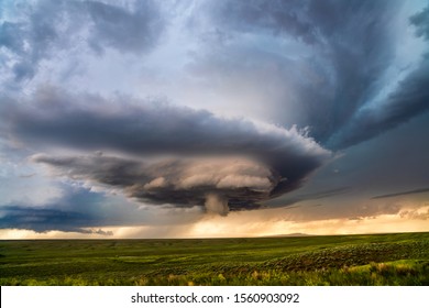 Supercell thunderstorm with dramatic clouds over a field