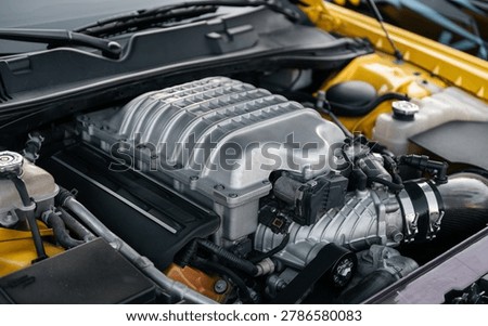 Supercharged engine close up. Powerful american V8 engine with forced induction - eight cylinder powerplant with aluminium supercharger bolted on top of.