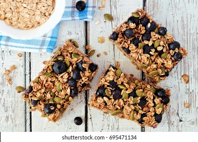 Superfood Breakfast Bars With Oats And Blueberries, Overhead On White Wood Background