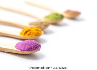 Superfood powders: sweet potato, matcha, spirulina, hemp, turmeric, carob in wooden spoons on a white background. - Powered by Shutterstock