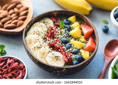 Superfood smoothie in coconut bowl with fruits and seeds toppings. Healthy eating, healthy lifestyle concept
