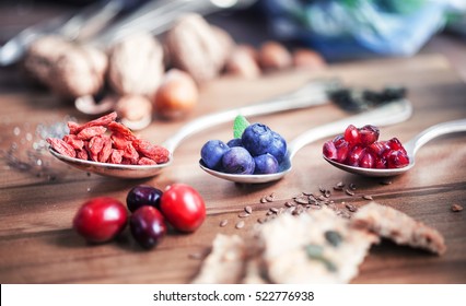 Superfood: Spoons of various healthy superfoods on wooden background