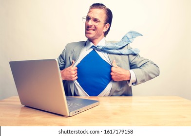 Superhero Businessman Giving A Cheeky Wink To The Camera As He Gets Ready To Save The Day From His Desk