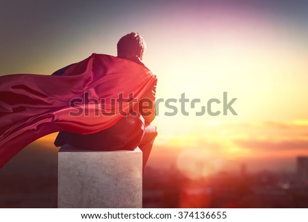 superhero businessman looking at city skyline at sunset. the concept of success, leadership and victory in business.
