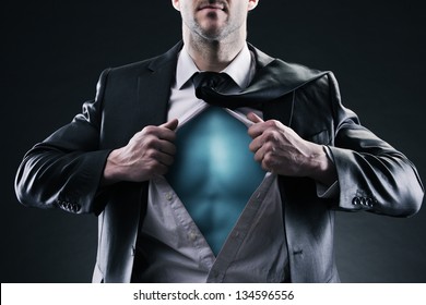 Superhero businessman pulls open shirt. Change and success concept.