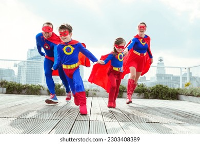 Superhero family playing on city rooftop - Powered by Shutterstock