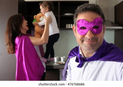 Superhero father and mother plays with their child ( girl age 02) in a home kitchen. Parents, Parenthood and family lifestyle concept. real people. copy space - Powered by Shutterstock