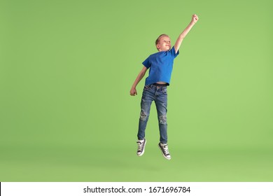 Superhero. Happy Boy Playing And Having Fun On Green Studio Background. Caucasian Kid In Bright Cloth Looks Playful, Laughting, Smiling. Concept Of Education, Childhood, Emotions, Facial Expression.