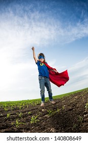 Superhero Kid Jumping Against Dramatic Blue Sky Background