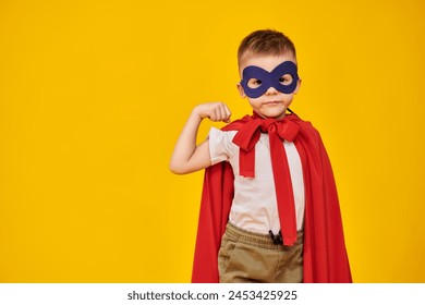 Superhero kids. Portrait of a little boy wearing a superhero costume on a yellow studio background. Children's dreams and fantasies. Copy space.  - Powered by Shutterstock