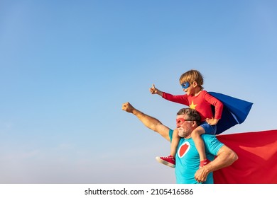 Superhero senior man and child playing outdoor. Super hero grandfather and boy having fun together. Family holiday concept. Happy Father's day
