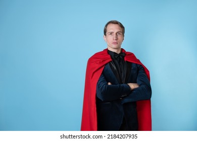 Superhero Stands In A Heroic Pose, A Man In A Business Suit And A Red Cape. Charismatic And Successful Business Hero.