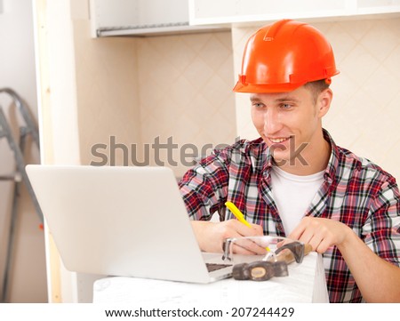 superintendent with the computer in the interior of a new apartment amends documents