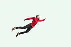 Superman Flying. Enthusiasm Concept. Strong Bearded Businessman In Red Shirt  Felt Himself A Superhero Or Super Man And Flying Up. Indoor Studio Shot Isolated On Gray Background.