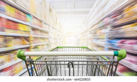 Supermarket aisle with empty green shopping cart