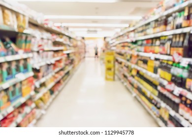 supermarket aisle with product on shelves blurred background - Shutterstock ID 1129945778