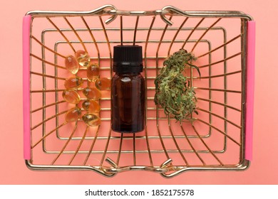 Supermarket Basket With Marijuana Bud And Medical Cannabis Oil Cbd On Pink Background.