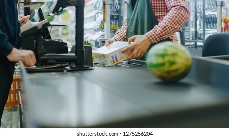 At the Supermarket: Checkout Counter Hands of the Cashier Scans Groceries, Fruits and other Healthy Food Items. Clean Modern Shopping Mall with Friendly Staff, Small Lines and Happy Customers. - Powered by Shutterstock