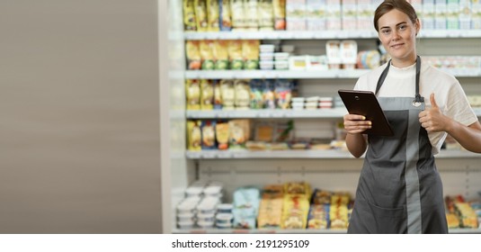 Supermarket Clerk Using Apps On A Digital Tablet, Innovative Technology And Work Concept, Young Female Supervisor With Tablet Pc In The Mall. Retail Concept