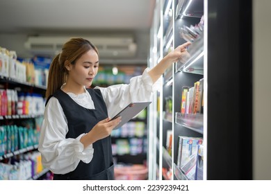 supermarket clerk using apps on a digital tablet, innovative technology, and work concept, and a young female supervisor with a tablet pc in the mall. - Powered by Shutterstock