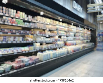 Supermarket Place Blur Background With Dairy Food Products And Beverage On Blurry Refrigerator Shelves