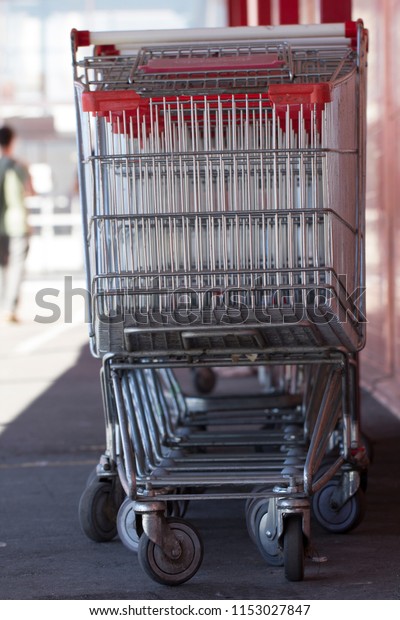 Supermarket shopping carts in a row in large\
supermarket store\
parking