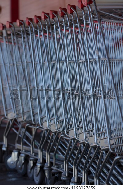 Supermarket shopping carts in a row in large\
supermarket store\
parking