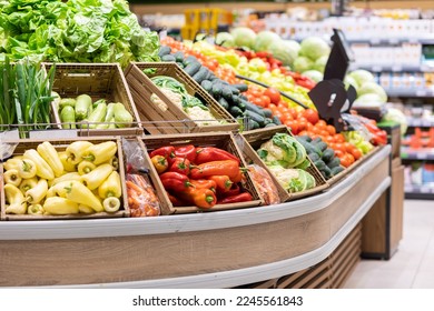 Supermarket showcase with wooden boxes of vegetables. Organic fresh broccoli, paprika, lettuce, onion. Concept of bio food and shopping in grocery store.