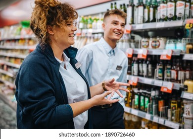 Supermarket Store Manager Giving Training To Young Worker. Grocery Store Manager Explaining The Way To Work To A New Male Employee.