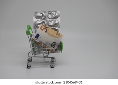 A Supermarket Trolley Full Of Blister Pills, A Lot Of Pills In A Wheelbarrow. Concept: Home Delivery Of Medicines.Empty Space, A Place For Text, Poster, Board. Medical Blue Background