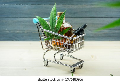 Supermarket trolley with marijuana leafs and medical cannabis oil cbd