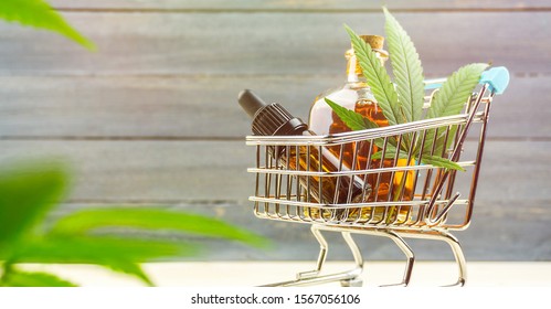 Supermarket trolley with marijuana leafs and medical cannabis oil cbd, Buying Cannabis products concept