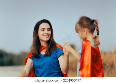 
Supermom Receiving A Bouquet Of Flowers From Her Loving Daughter. Mom Receiving A Floral Bouquet From Her Adorable Little Girl
