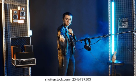 Superstar female artist throwing air punches in celebration for something, rebellious confident attitude. Musician with an energetic edgy vibe determined for a great performance. Camera B. - Powered by Shutterstock