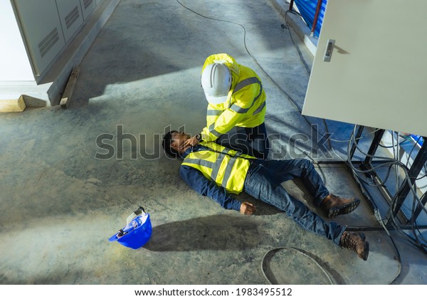 Supervisor first aid help injured worker\
accident electric shock unconscious. Asian electrician worker\
accident electric shock unconscious in site\
work.