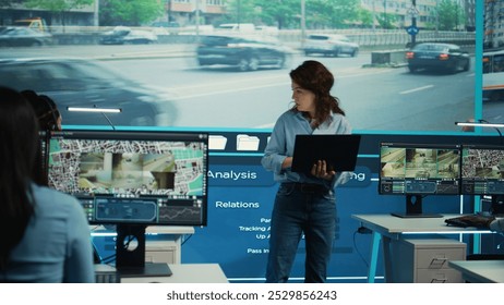 Supervisor gathering intelligence from satellite based surveillance footage, diverse team of operators analyzing traffic through security cameras. Control center license plate reading. Camera B.