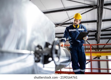 Supervisor inspecting pipes in heating energy plant. - Powered by Shutterstock